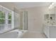 Bathroom featuring a soaking tub, glass shower, and double mirrors at 1131 Indigo Dr, Kissimmee, FL 34747