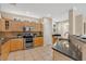 Well-lit kitchen featuring tile floors, granite counters, and wood cabinets at 1131 Indigo Dr, Kissimmee, FL 34747