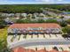 Aerial view showing colorful townhomes in a well-maintained community with tree-lined streets at 1180 S Beach Cir, Kissimmee, FL 34746