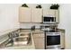 The kitchen is equipped with stainless steel appliances and light wood cabinets with access to dining at 1180 S Beach Cir, Kissimmee, FL 34746