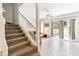 Stairway view into the living room featuring neutral decor, and sliding doors to the patio at 1180 S Beach Cir, Kissimmee, FL 34746
