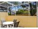 Enclosed patio with outdoor seating for four, screened for comfort and privacy, offers a relaxing space with backyard views at 1180 S Beach Cir, Kissimmee, FL 34746