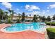 Large community pool surrounded by lush landscaping, lounge chairs, and clear blue skies at 1180 S Beach Cir, Kissimmee, FL 34746