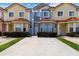 Row of colorful townhouses with red tile roofs, bay windows, and landscaped front yards on a sunny day at 1180 S Beach Cir, Kissimmee, FL 34746