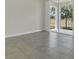 Open-concept living room featuring ceramic tile flooring and sliding glass doors to the patio at 12307 Turtle Grass Dr, Orlando, FL 32824