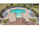 A high angle aerial view showing a community pool with ample seating surrounded by mature landscaping at 12307 Turtle Grass Dr, Orlando, FL 32824