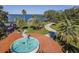 Aerial view of a tranquil lakeside park with a decorative fountain, walkways, and stunning water views at 1247 Blue Daze Ln, Eustis, FL 32726