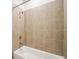 Full bathtub featuring light beige tiling and contemporary shower head at 1247 Blue Daze Ln, Eustis, FL 32726