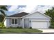 Charming one-story home with a two car garage, well-maintained lawn, and beautiful landscaping at 1247 Blue Daze Ln, Eustis, FL 32726