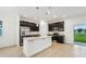 A kitchen with dark cabinets and stainless steel appliances including an island and granite countertops at 1247 Blue Daze Ln, Eustis, FL 32726