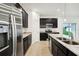 Modern kitchen features stainless steel appliances and granite countertops with dark cabinets at 1247 Blue Daze Ln, Eustis, FL 32726