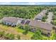 An aerial view showing a row of townhomes with well-manicured lawns and a backdrop of lush greenery at 1262 E 10Th St, Apopka, FL 32703