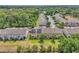Aerial view of townhomes with green lawns and trees, some featuring solar panels, near wooded area at 1262 E 10Th St, Apopka, FL 32703