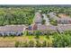 Aerial view of townhomes with green lawns and trees, some featuring solar panels, near wooded area at 1262 E 10Th St, Apopka, FL 32703