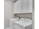 Well-lit laundry room featuring white washer and dryer beneath matching white cabinets at 1262 E 10Th St, Apopka, FL 32703
