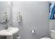 Powder room featuring a pedestal sink, round mirror, and modern fixtures at 13437 Granger Ave, Orlando, FL 32827