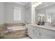 Spa-like bathroom featuring a soaking tub, double vanity, and elegant tile work at 13437 Granger Ave, Orlando, FL 32827