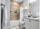 Bright bathroom featuring a tiled shower-tub, white vanity, and decorative accents at 13437 Granger Ave, Orlando, FL 32827