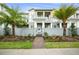 Attractive townhouse with palms, lawn and walkway to the front door at 13437 Granger Ave, Orlando, FL 32827