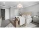 Luxurious main bedroom with tufted headboard, chandelier, and a cozy sitting area at 13437 Granger Ave, Orlando, FL 32827