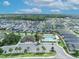 An aerial view shows a community pool and amenity center surrounded by well-maintained homes and lush landscaping at 1397 Gatlin Pl, The Villages, FL 32163