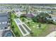 An aerial view of community amenities features a pool, clubhouse, bocce ball courts, lake, and manicured lawns at 1397 Gatlin Pl, The Villages, FL 32163