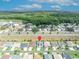 Aerial view of homes along a street, showcasing residential properties, landscaping and a nearby wooded area at 1397 Gatlin Pl, The Villages, FL 32163