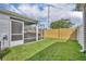Well-maintained backyard with a screened lanai featuring a hot tub, surrounded by lush green grass and a privacy fence at 1397 Gatlin Pl, The Villages, FL 32163