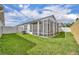 Grassy backyard featuring a screened-in lanai, providing a perfect outdoor space for relaxation and entertainment at 1397 Gatlin Pl, The Villages, FL 32163