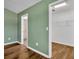 Bedroom with green walls and wood flooring with view into walk-in closet and en suite bathroom at 1397 Gatlin Pl, The Villages, FL 32163