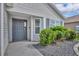 Close-up of the inviting front entrance with a gray front door and manicured landscaping at 1397 Gatlin Pl, The Villages, FL 32163