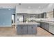 Open-concept kitchen with island, grey cabinets and stainless steel appliances at 1397 Gatlin Pl, The Villages, FL 32163