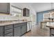 Kitchen sink and dishwasher with granite countertops and grey cabinets at 1397 Gatlin Pl, The Villages, FL 32163