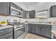 Stainless steel appliances and grey cabinets in the kitchen at 1397 Gatlin Pl, The Villages, FL 32163