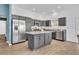 Spacious kitchen with an island, stainless steel appliances, and grey cabinets at 1397 Gatlin Pl, The Villages, FL 32163