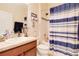 Bathroom features a single sink vanity with nautical decor and a shower with a blue and white curtain at 1405 Osprey Ridge Dr, Eustis, FL 32736