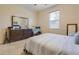 Bedroom with large window, neutral walls, carpet, and a view of the bed and a chest of drawers at 1405 Osprey Ridge Dr, Eustis, FL 32736