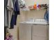 Laundry room offers a washer, dryer, storage shelves, and hanging space for freshly laundered clothes at 1405 Osprey Ridge Dr, Eustis, FL 32736