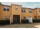 View of the townhome's rear exterior with screened patio and landscaping at 1441 Twin Trees Ln, Sanford, FL 32771