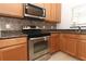 Well-equipped kitchen featuring stainless steel appliances, granite countertops, and wood cabinets at 1441 Twin Trees Ln, Sanford, FL 32771