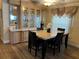 Charming dining area with wood floors, built-in glass cabinets and a marble-topped table with seating for four at 158 Rita Bee Ave, Davenport, FL 33897