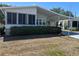 Welcoming home featuring a carport and sunroom, surrounded by green shrubs and a well-kept lawn at 158 Rita Bee Ave, Davenport, FL 33897