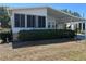 Cozy home showcasing a sunroom and carport, complemented by lush shrubs enhancing the property's charm at 158 Rita Bee Ave, Davenport, FL 33897