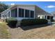 Inviting home with a sunroom and carport, enhanced by manicured shrubs for added privacy and curb appeal at 158 Rita Bee Ave, Davenport, FL 33897