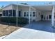 Well-maintained single-story home featuring a covered carport and enclosed sunroom, nestled amongst mature shrubs at 158 Rita Bee Ave, Davenport, FL 33897