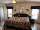 Comfortable main bedroom featuring a large bed with patterned bedding, dark furniture and wood floors at 158 Rita Bee Ave, Davenport, FL 33897