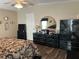 Well-appointed main bedroom featuring dark wood furniture and floors, a ceiling fan and a large mirror at 158 Rita Bee Ave, Davenport, FL 33897