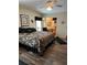 Comfortable main bedroom featuring a large bed with patterned bedding, dark furniture and a view to the ensuite bath at 158 Rita Bee Ave, Davenport, FL 33897