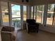 Enclosed sunroom with floor to ceiling windows and two cozy armchairs at 158 Rita Bee Ave, Davenport, FL 33897