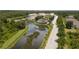 Aerial view of tree-lined street in a residential neighborhood with a lake and green spaces at 17419 Placidity Ave, Clermont, FL 34714